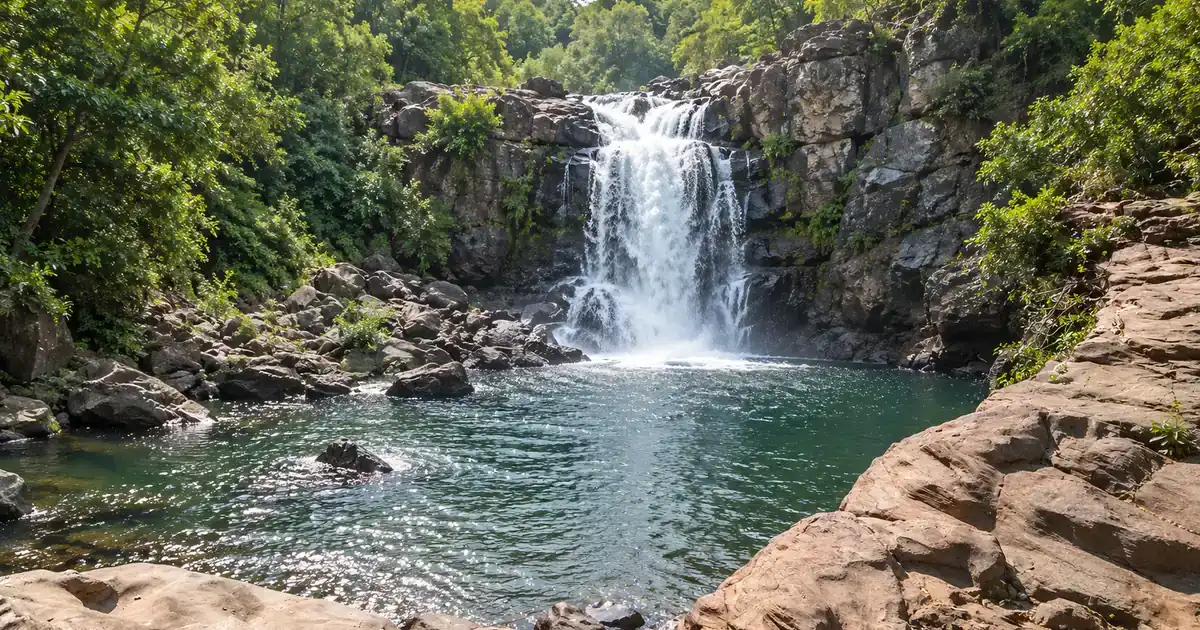 Illustrative view of Koilighughar Waterfall dropping into a forest pool