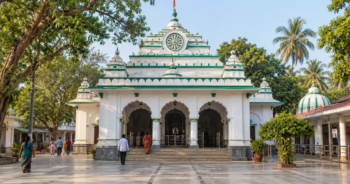 Illustrative white temple facade with green trim and arched entrance at Maa Sarala Temple