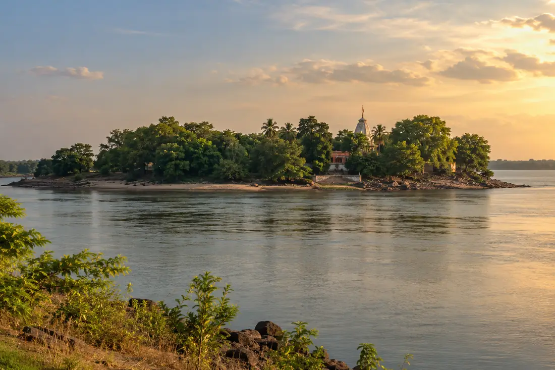 Trees and a small shrine stand on an island in the Mahanadi at Dhabaleswar