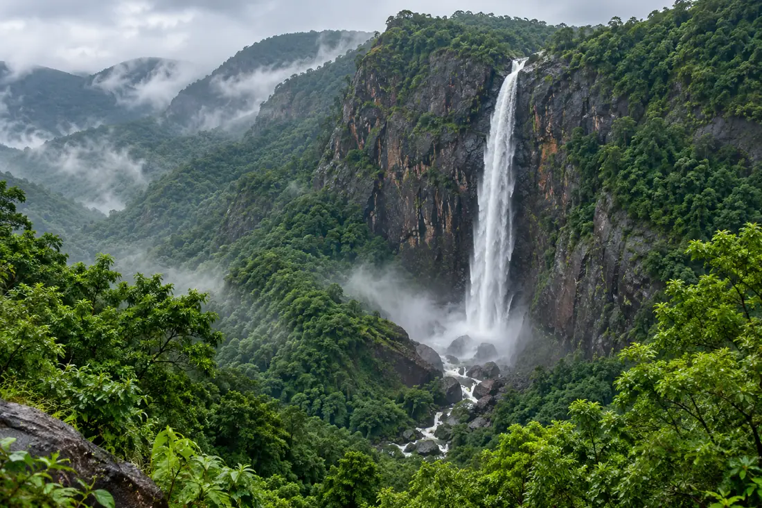 A waterfall flows through a forested valley in Sundargarh